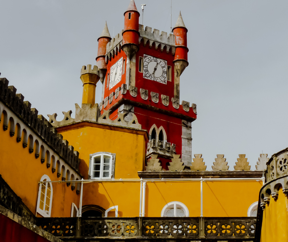 a red tower and yellow building as part of a castle